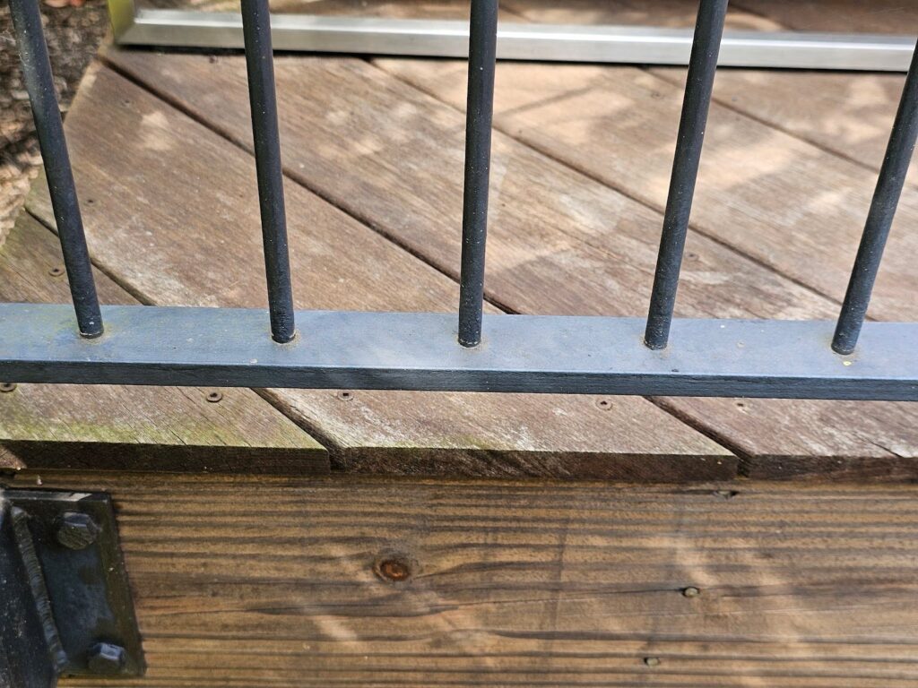 Loose metal handrail connection on a wood deck railing system