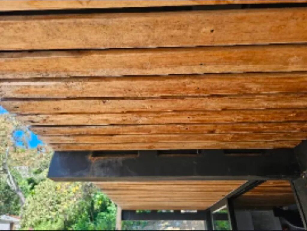 Architectural overhang extending above a porch to enhance outdoor comfort and shelter