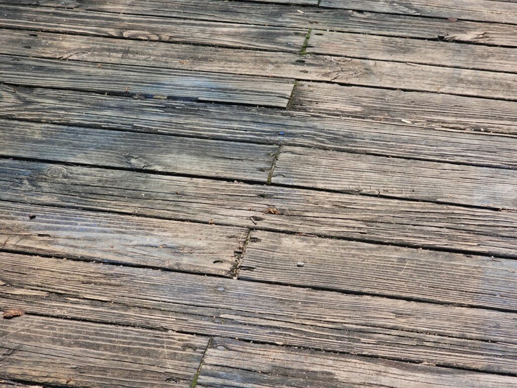 Applying stain to weathered wood deck boards